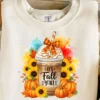 Mockup of “It’s Fall Y’all” sublimation PNG design on a women’s fall sweatshirt with pumpkin spice coffee, sunflowers, and plaid bow