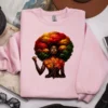 Light pink sweatshirt displaying afrocentric empowerment artwork