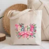 Canvas tote bag featuring a pink coquette bow teacher design