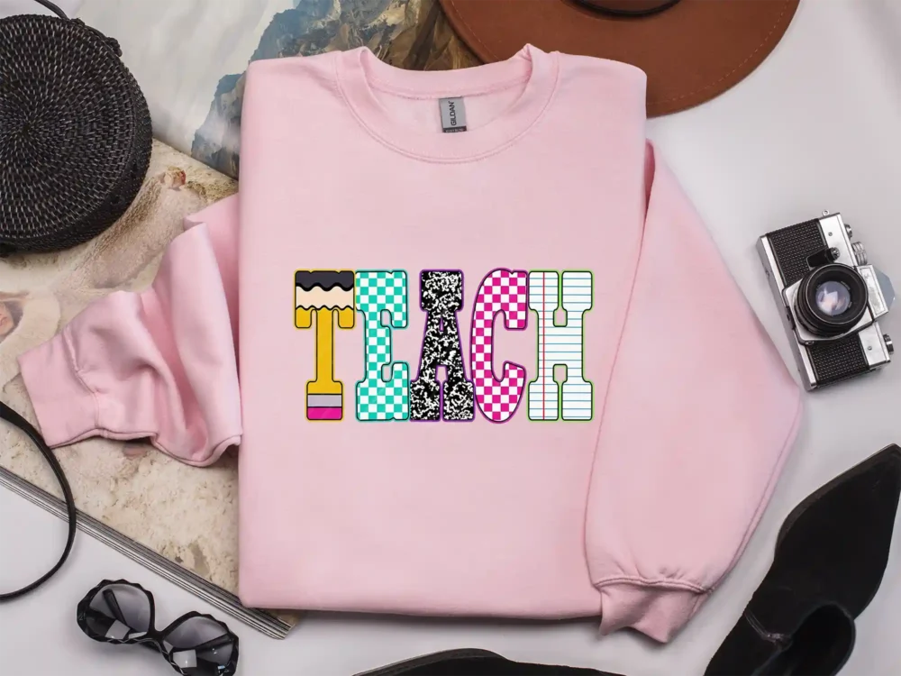 Light pink sweatshirt featuring the Neon Checkered TEACH PNG