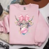 Light pink sweatshirt displaying cute highland cow artwork