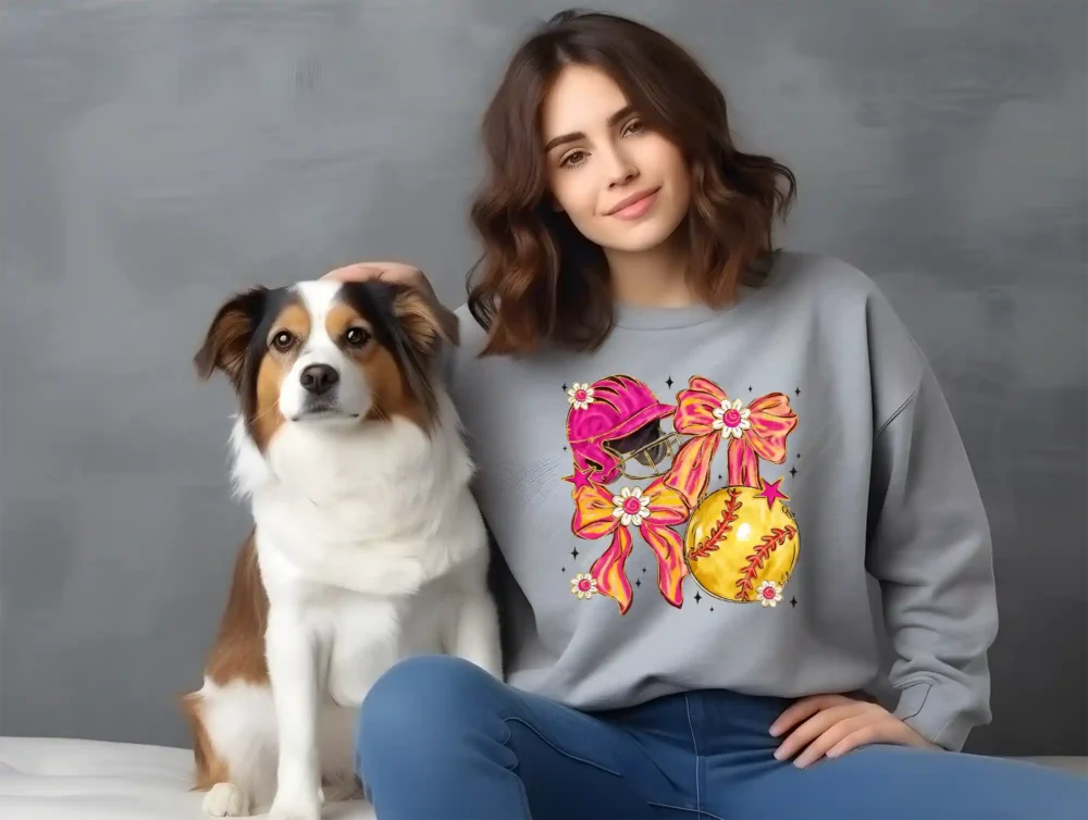 Girl and her dog wearing a grey sweatshirt with a softball coquette graphic