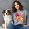 Girl and her dog wearing a grey sweatshirt with a softball coquette graphic