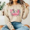 Girl wearing a tan hoodie with a faux yarn floral graphic
