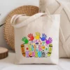 Canvas tote bag featuring a colorful crayon teacher design