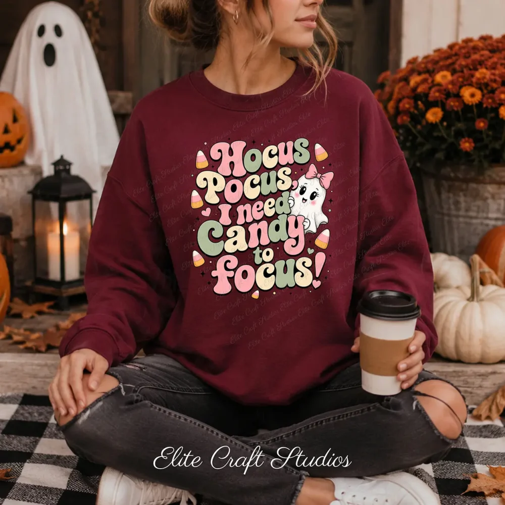 Woman wearing a maroon crewneck sweatshirt with a funny Halloween PNG sublimation design, sitting cross-legged on a plaid blanket next to pumpkins, a lantern, and a white ghost.