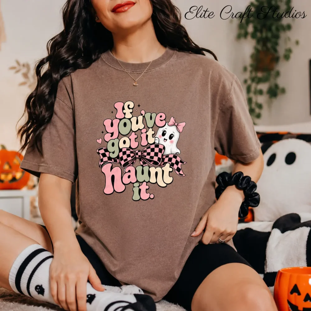 A woman wearing a cocoa-brown t-shirt sitting on a rug next to a ghost pillow