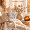 A cozy close-up of a person wrapped in a cream knit blanket, holding a ceramic mug custom printed with the groovy retro Halloween ghost design near a sunlit window.