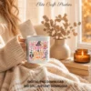 Person wrapped in a cozy knit blanket holding a white ceramic coffee mug printed with the pastel Creepy and Cute graphic.