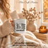 White ceramic coffee mug printed with the Mombie design held by a woman wrapped in a warm knit sweater.