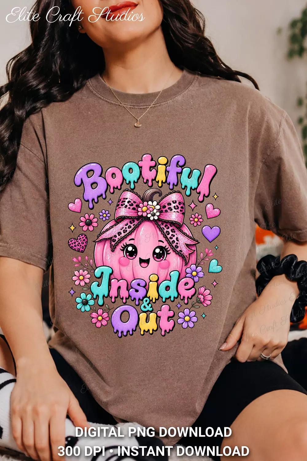Woman wearing an earth brown t-shirt featuring the Bootiful Inside and Out design with a pink pumpkin and melting lettering.