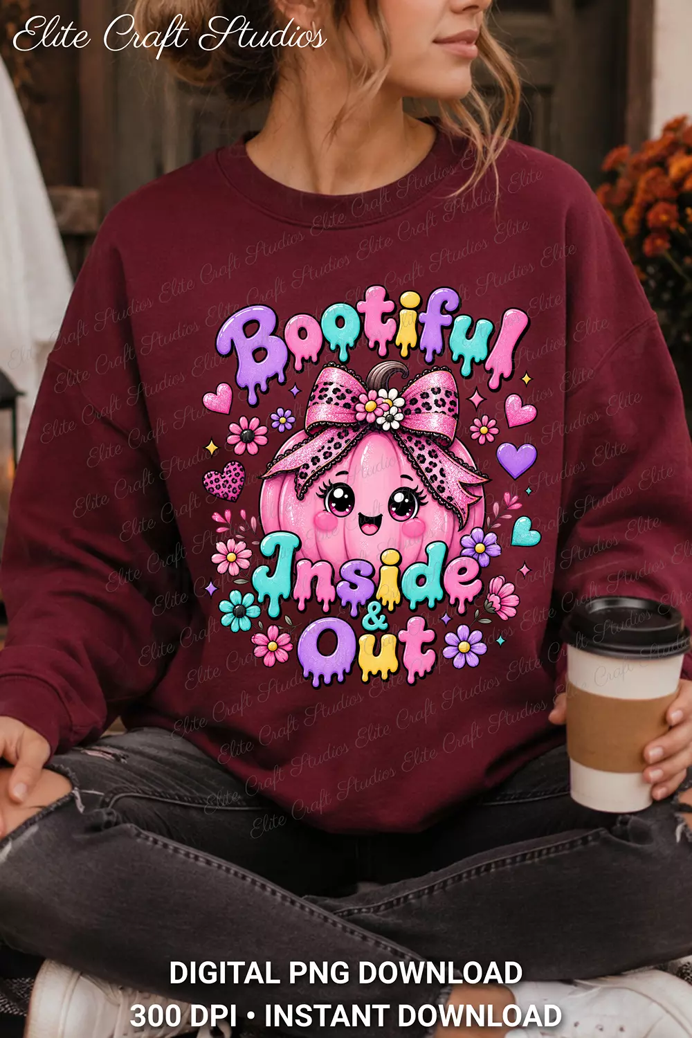 Model wearing a cozy maroon crewneck sweatshirt with the Bootiful Inside and Out pink pumpkin design, holding a to-go coffee cup.