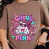 Model in a faded taupe brown t-shirt showcasing the Just a Ghoul Who Loves Pink graphic with leopard accents and floral details.