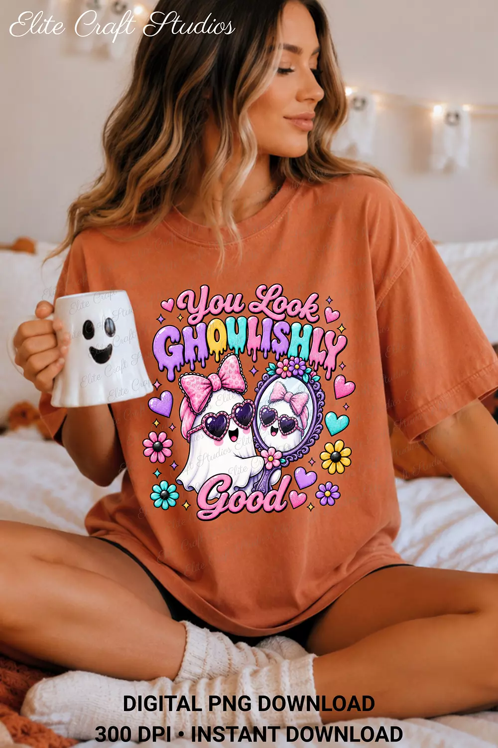 Woman wearing an oversized terracotta t-shirt printed with the pastel ghost artwork while holding a white ghost coffee mug in bed.