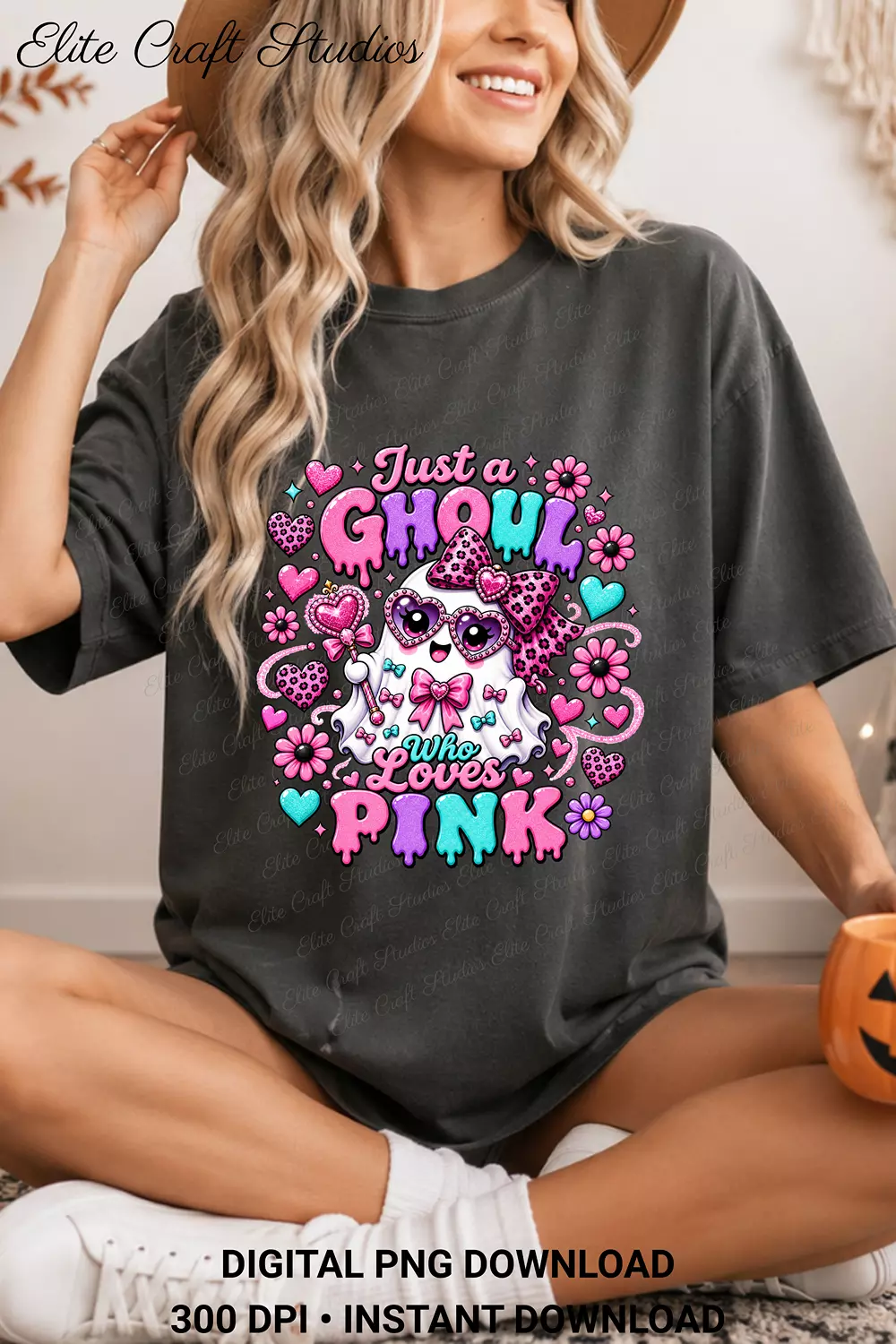 Woman wearing an oversized charcoal gray graphic t-shirt featuring the Just a Ghoul Who Loves Pink sublimation design while holding a small pumpkin.