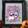 An ornate black picture frame displaying the You Look Ghoulishly Good ghost art on a shelf flanked by two carved jack-o'-lantern pumpkins.