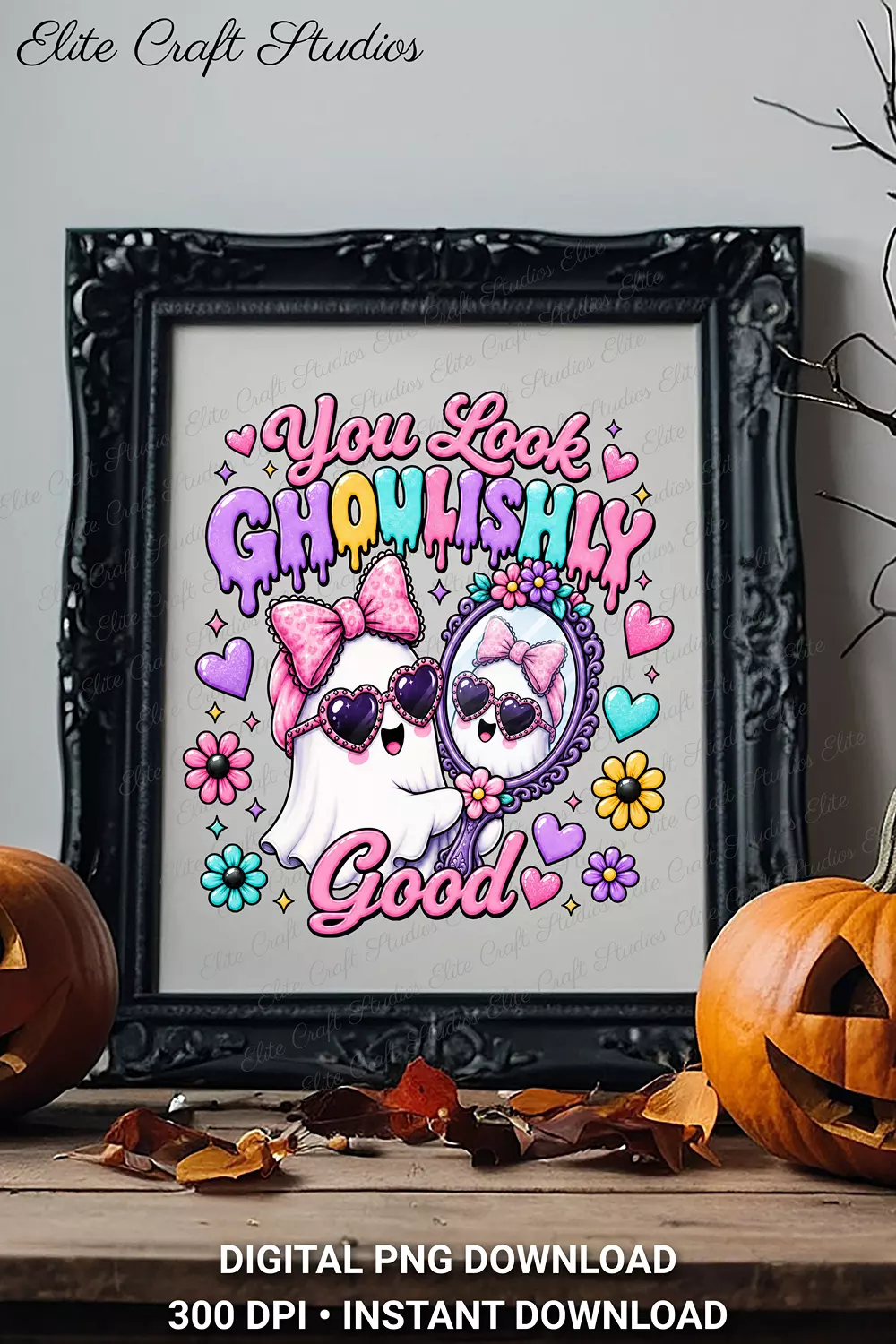An ornate black picture frame displaying the You Look Ghoulishly Good ghost art on a shelf flanked by two carved jack-o'-lantern pumpkins.