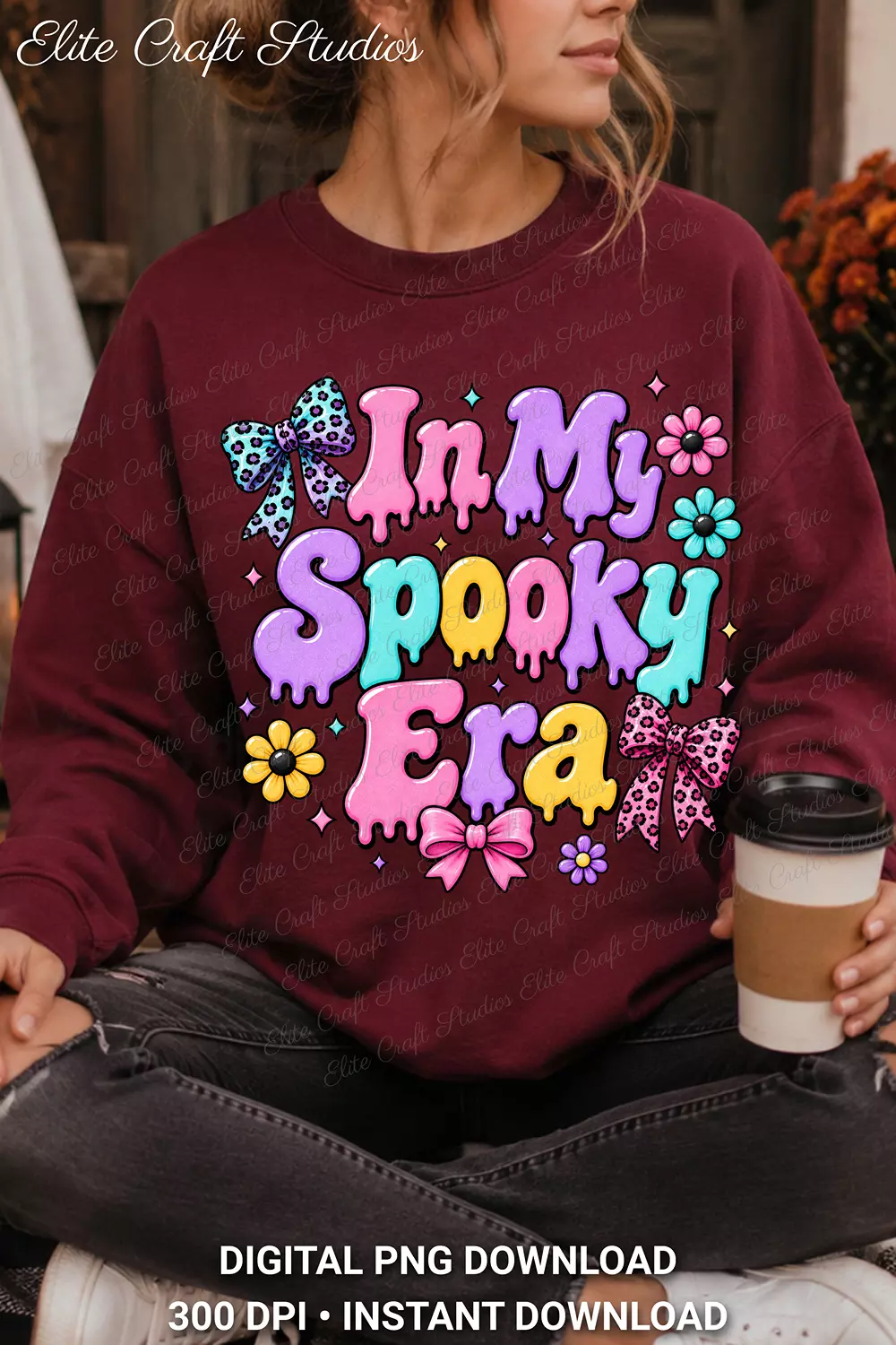 Woman wearing an oversized maroon crewneck sweatshirt with the In My Spooky Era dripping font design while holding a to-go coffee cup.