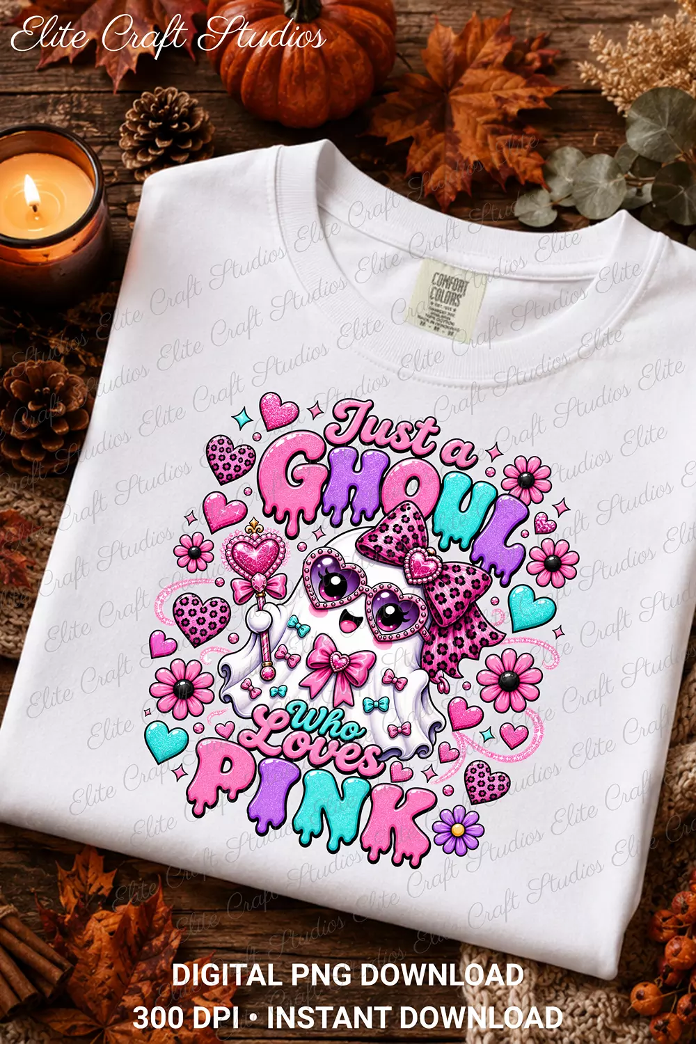 Flat lay mockup of a white Comfort Colors t-shirt printed with the Just a Ghoul Who Loves Pink ghost design, arranged with autumn leaves, pine cones, and a lit candle.