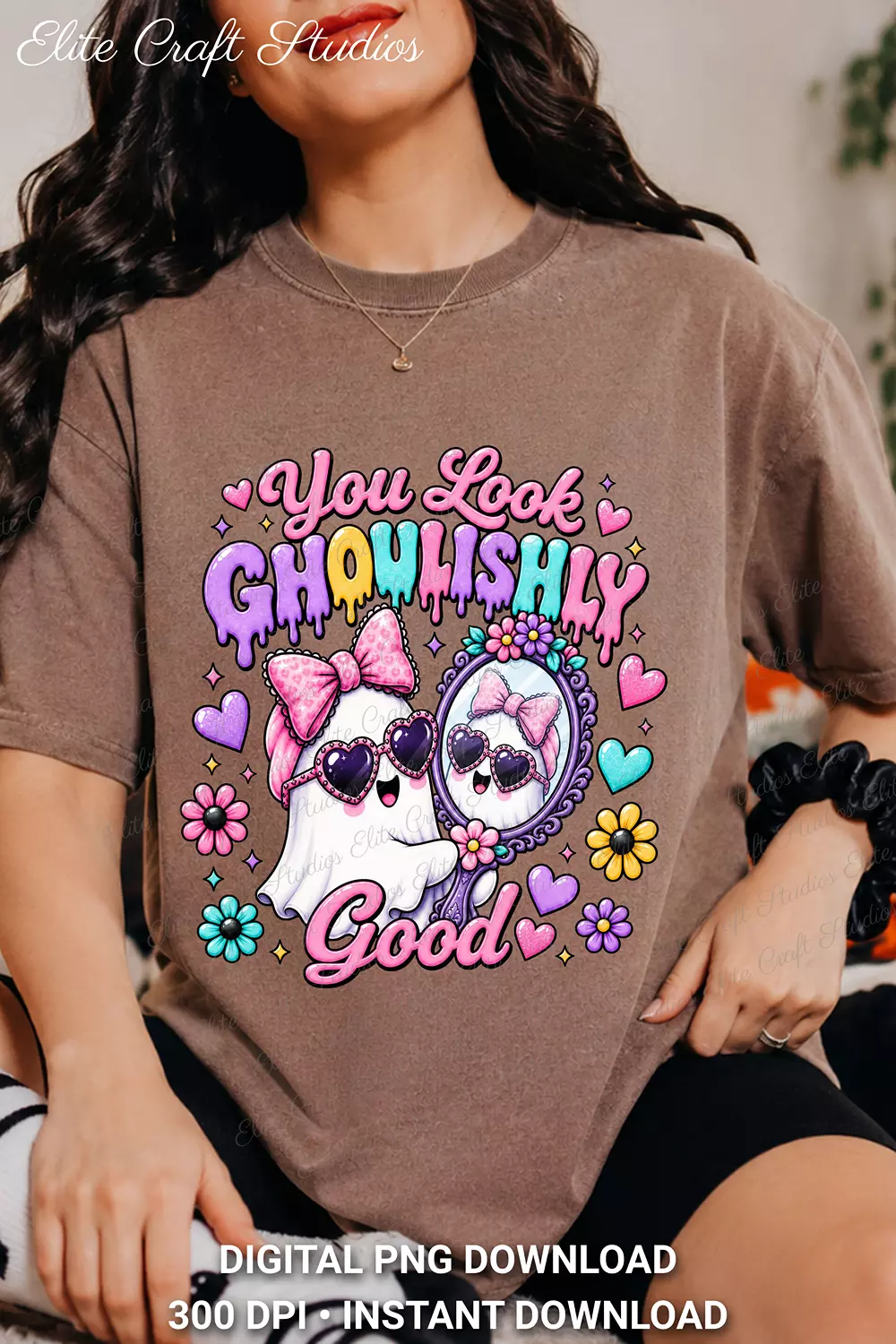 Model seated wearing a washed brown t-shirt featuring the pastel You Look Ghoulishly Good ghost design on the front.