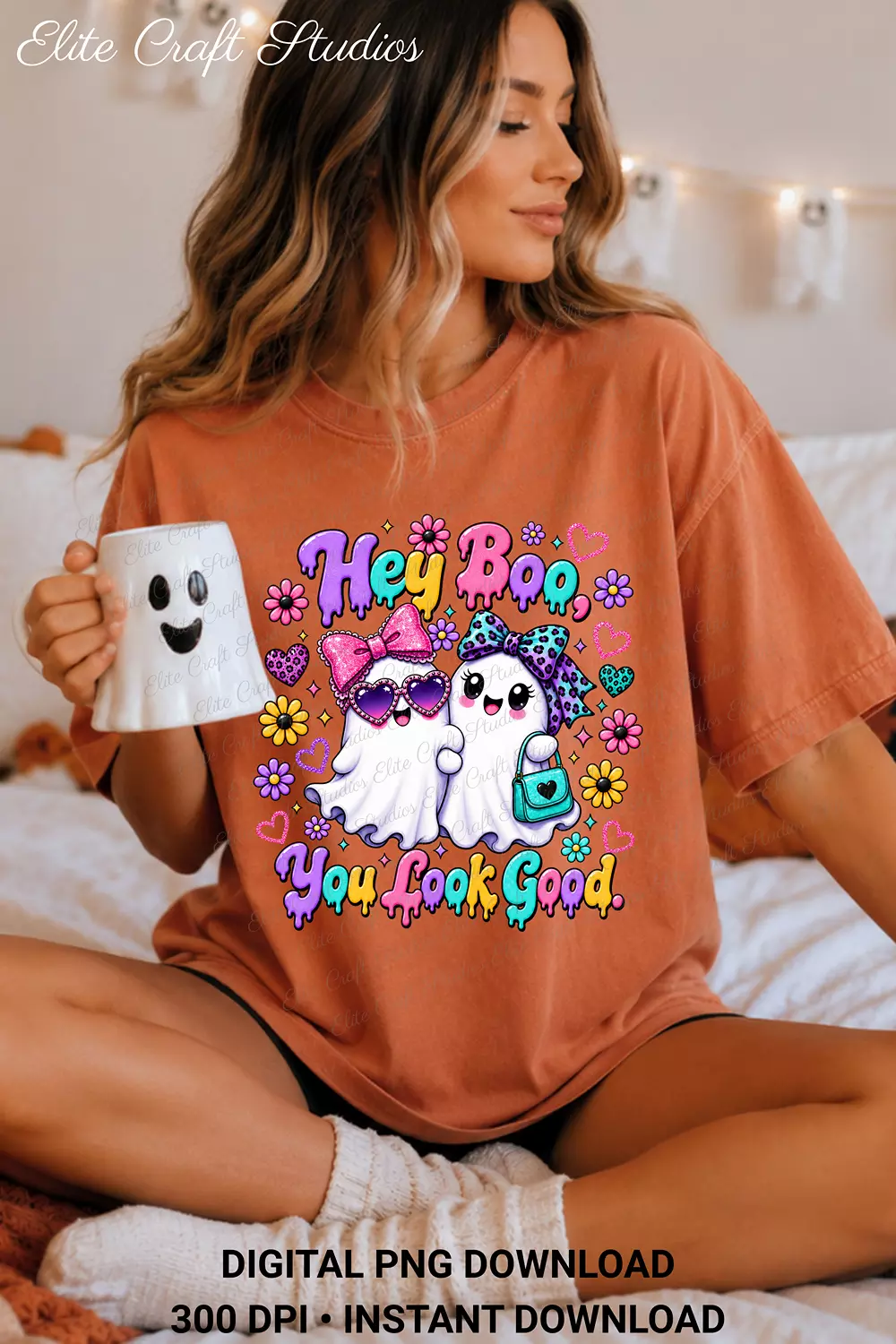 Woman sitting in bed wearing an orange terracotta t-shirt printed with the Hey Boo You Look Good graphic while holding a ghost mug.