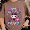 Close-up of a model wearing a relaxed-fit mocha brown t-shirt featuring the colorful Spookily Obsessed with Coffee sublimation graphic.
